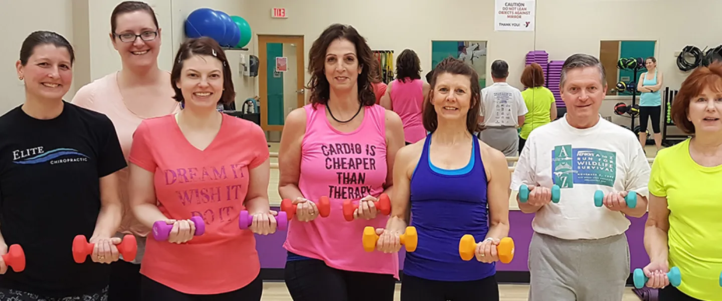 group of adults holding weights