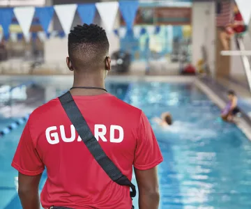 Lifeguard from back standing on pool deck