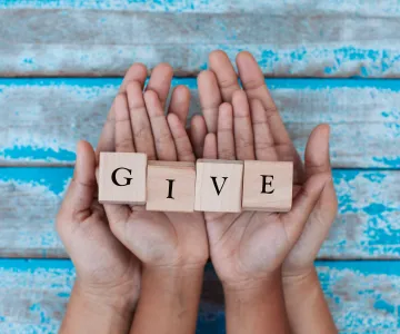 hands holding the word 'give'