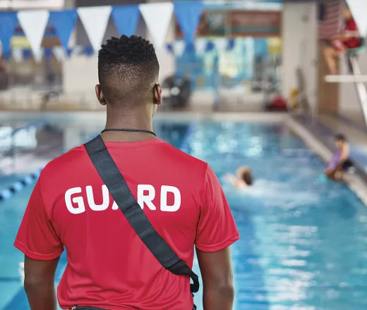 Lifeguard from back standing on pool deck