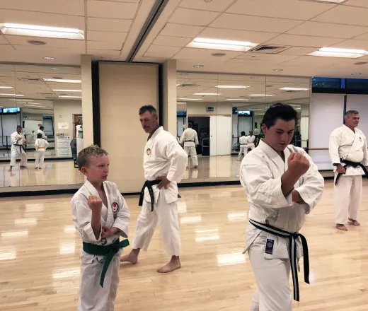 youth and adult doing karate with instructor in background