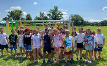 group of 30 children pose for outdoor photo